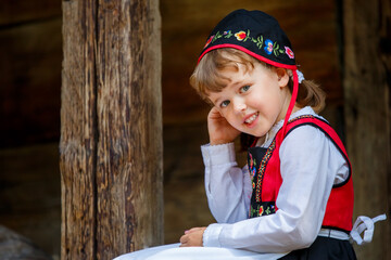 Adorable little girl in Swedish traditional clothes during Midsommar festival - 502481876