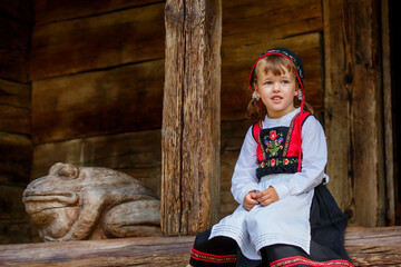 Adorable little girl in Swedish traditional clothes during Midsommar festival - 502481879