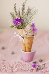 Walnut ice cream, a composition in the colors of pink and violet with a bouquet of violet flowers, close-up.