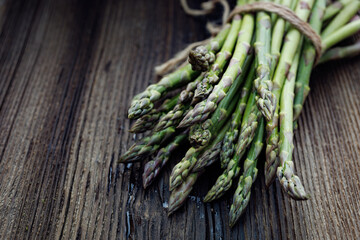 Bunch of fresh green asparagus on a wooden table, close up view
