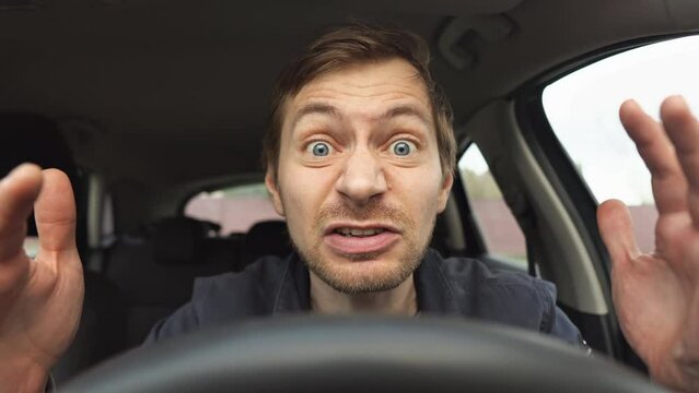 Angry man driving a car. Male driver screaming behind the wheel of the car.