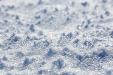 Snow surface close-up. Shallow depth of field and blur. Winter background.
