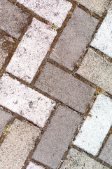 Closeup of sidewalk paved with rectangular white and gray tiles in top view