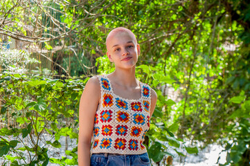Portrait of a girl with very short hair, dyed pink. Portrait of girl wearing crochet outfit. Portrait of almost bald girl.