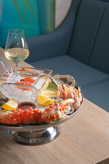 Dish with red caviar, shrimp, crab sauce and other seafood. Served with glasses of white wine in a restaurant.