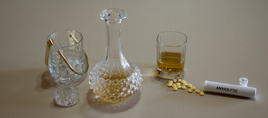Image of a jug with ice a glass and a bottle of whiskey with a box of anxiolytics next to it. Reference to addictions and problems of some substances. Horizontal banner 