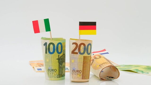 Economy of European countries.Flags of Germany, France and Italy and falling euro bills on a white background.Changes in the budget of European countries. Inflation and economic recession in Europe