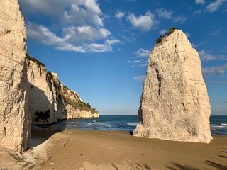 Fototapeta na wymiar Wahrzeichen der Stadt Vieste - Monolith Pizzomunno, - Kalksteinfelsen am Strand - Spiaggia di Castello in Apulien am Strand vom Meer / Adria in Italien