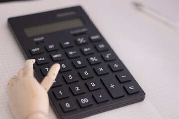 計算　計算機と手 /  a calculator and a hand on white note 