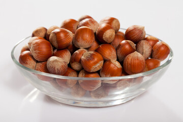 Unpeeled hazelnut in glass cup