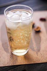 Chrysanthemum Juice, chilled, served in a clear glass placed on a black table