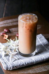 Iced coffee on a leaf-shaped placemat with white flowers.
