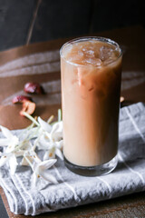 Iced coffee on a leaf-shaped placemat with white flowers.
