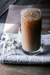 Iced coffee on a leaf-shaped placemat with white flowers.