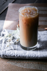 Iced coffee on a leaf-shaped placemat with white flowers.