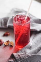 roselle juice in a glass, placed on a white table.
