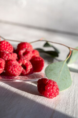 delicious raspberries on plate on sunny bright morning. 
