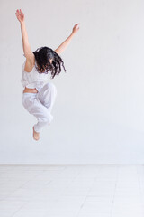 Young woman performing Contemporary dance in a white studio