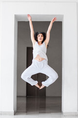 Young woman performing a dance jump in a studio