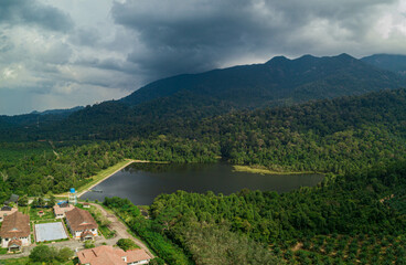 Aerial drone view of a dam lake with tropical trees in Mount Ledang National Park, Johor, Malaysia.