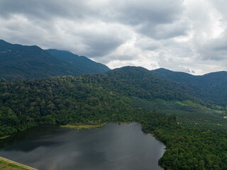 Aerial drone view of a dam lake with tropical trees in Mount Ledang National Park, Johor, Malaysia.