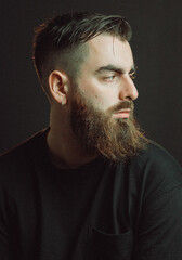 Frontal cinematic portrait of a handsome man with beard. Looking serious and worried about the...