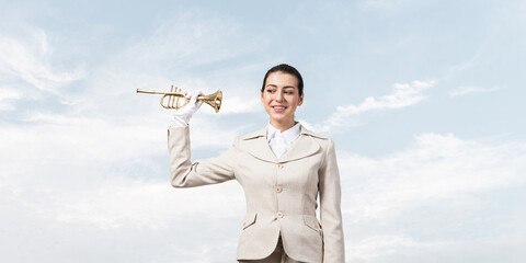 Beautiful woman holding trumpet brass near ear © adam121