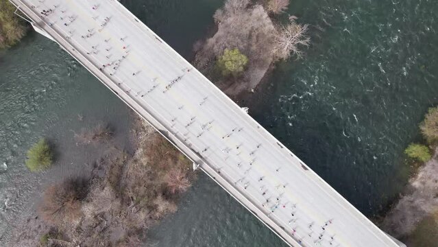 hyperlapse people running on bridge over river