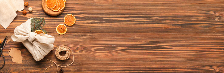 Christmas gifts, dried orange slices and fir branches on wooden background with space for text