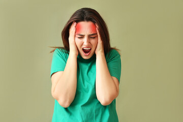 Stressed young woman suffering from headache on color background