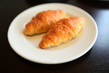 brown croissant put in white plate
