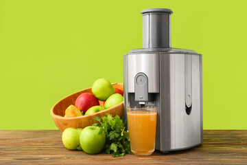 New modern juicer and glass of fresh juice with fruits on wooden table