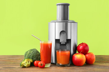 New modern juicer and glasses of fresh juice on wooden table