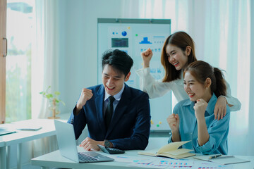 A group of young Asian businessmen working as a team brainstorm, analyze a financial chart, or discuss a marketing plan. Women leaders present and plan new business strategies. teamwork concept