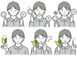 〇✕マークや初心者マークを持つ若い男性