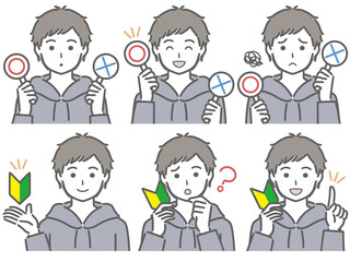 〇✕マークや初心者マークを持つ若い男性