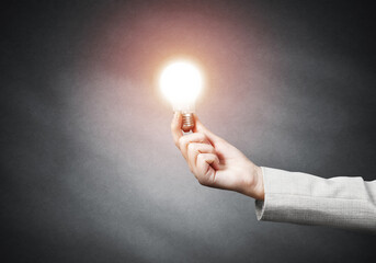 Human hand with glowing incandescent lamp