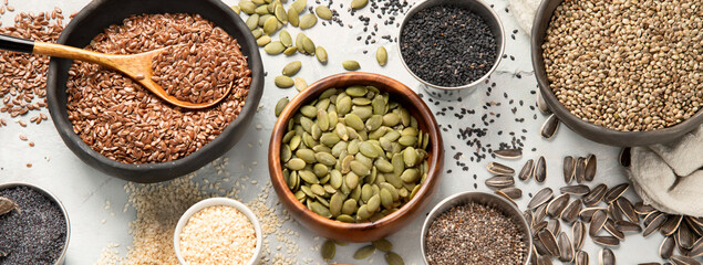 Variety of edible seeds on light background.