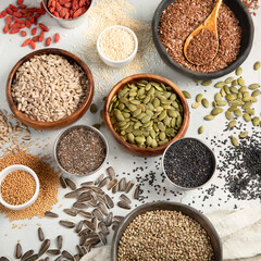 Variety of edible seeds on light background.