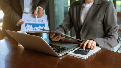 business woman manager analyzing datum in charts and typing on computer, making notes in documents on the table in office,  business team concept..