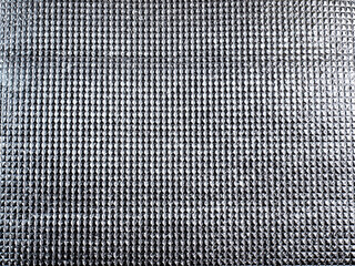 The surface of the silver reflector reflects light, the surface pattern is a small rectangular grid.