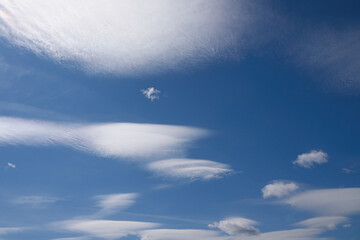 Clouds of an unusual shape along with ordinary clouds in a blue sky.
