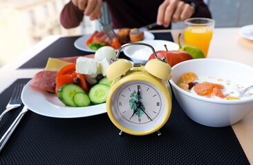 Selective focus of  yellow  alarm  clock as  a Intermittent fasting low carb hight fats diet concept