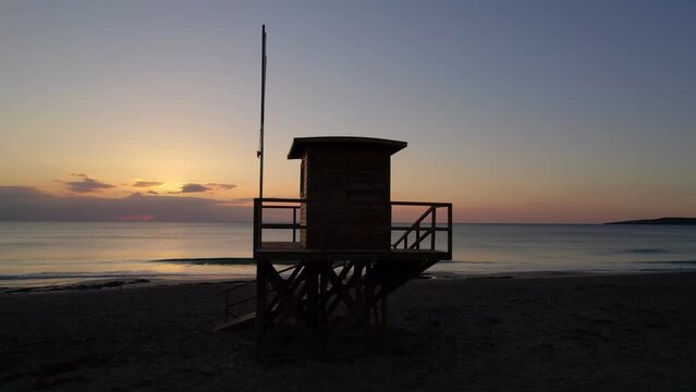 Lifeguard House silhouette, colourful dawn, drone orbit, Cala Millor Mallorca