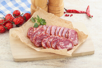Sliced salami sausages over board