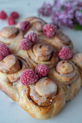Delicious freshly baked cinnamon roll with raspberries