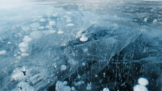 Beautiful transparent blue ice and frozen methane bubbles on Baikal Lake background texture, 4k
