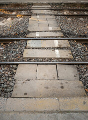 The concrete block pathway for crossing the railway track.