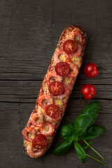 Homemade baguette sandwich or pizza with shrimp, cherry tomatoes and fresh basil. Top view photo on a wooden background with place for your text.