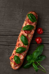 Homemade baguette sandwich or pizza with shrimp, cherry tomatoes and fresh basil leaves on top. Top view photo on a wooden background with place for your text.